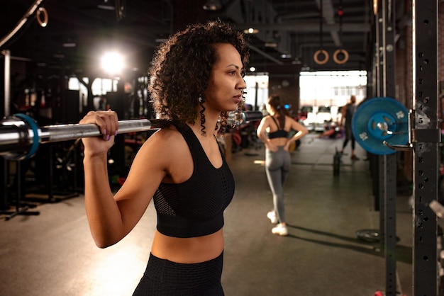 Sexy linda mulher afro-americana malhando com uma barra na academia copyspace esportes estilo de vida wrestling estar em boa forma