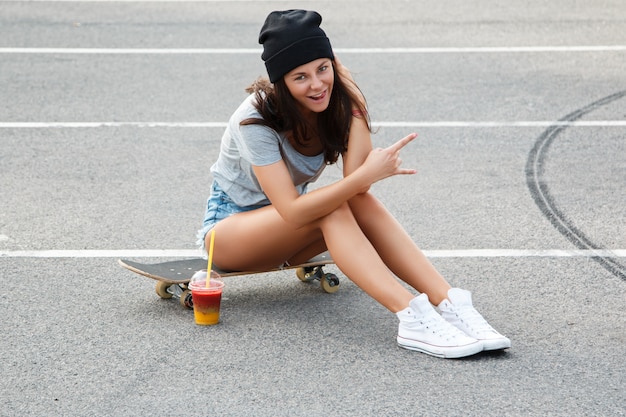 Sexy Mädchen sitzt auf dem Skateboard