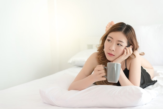 Sexy mujer delgada asiática posando en la cama