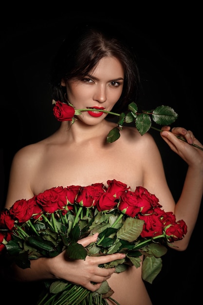 Sexy mujer hermosa con gran ramo de rosas rojas