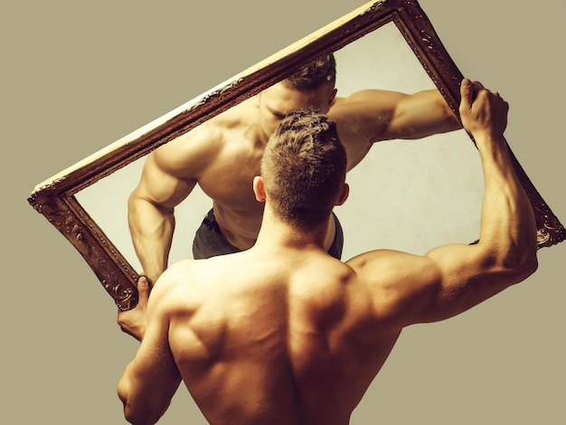 Sexy muskulöser Mann mit Spiegel