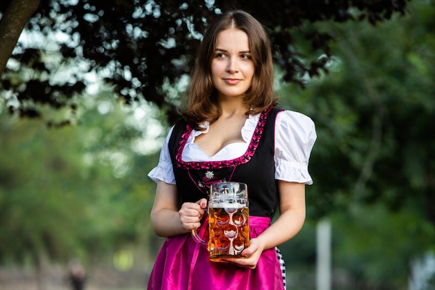 Foto sexy russische frau im bayerischen kleid hält bierkrüge