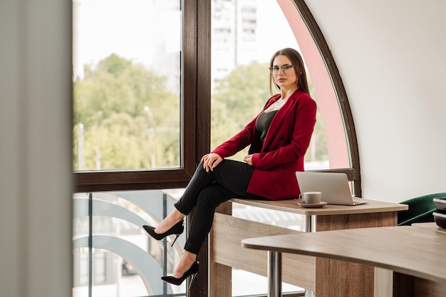 Sexy Sekretärin posiert am Fenster im Büro