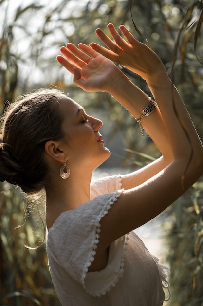 Foto sexy sensual retrato de una niña, modelo en vestido blanco en el fondo de cañas