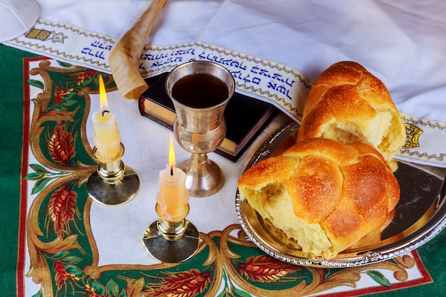 Shabat mesa de véspera com chalá pão, velas e kipá.