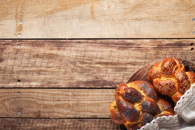 Shabbat Shalom Challah-Brot mit Sesam und Mohn auf Holzhintergrund Traditionelles jüdisches Brot für Shabbat und Feiertage Rustikales Konzept Kopierbereich Selektiver Fokus