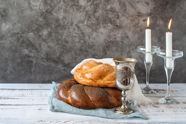 Shabbat Shalom challah pão vinho de shabbat e velas em fundo cinza com espaço de cópia