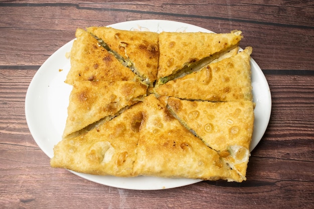 Shahi Mughlai paratha servido em prato isolado na mesa de madeira vista de especiarias indianas comida