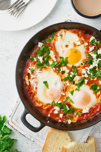 Shakshouka, huevos escalfados en salsa de tomates, aceite de oliva. Cocina mediterránea.