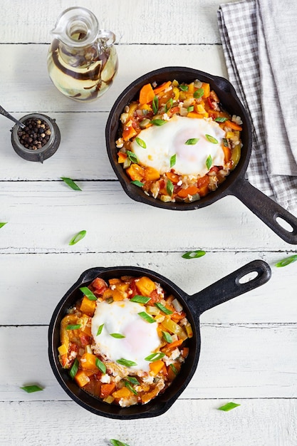 Shakshouka na frigideira Ovos fritos com legumes tomate pimenta abóbora e cebola Vista superior