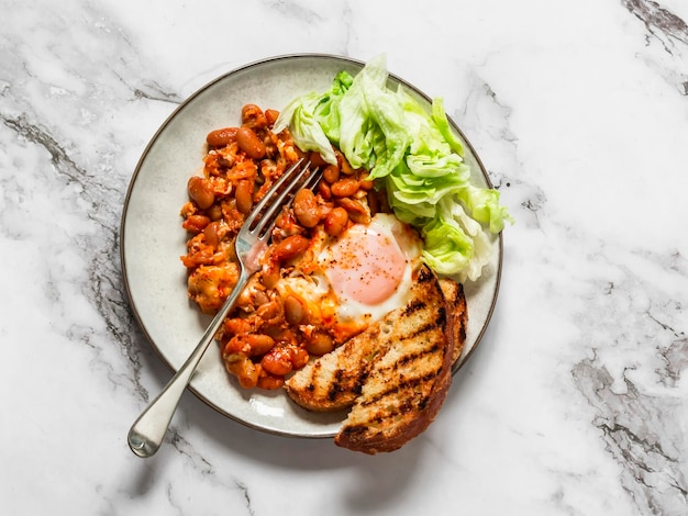 Shakshuka assado com molho de tomate e salada de iceberg é um delicioso café da manhã saudável em uma vista superior de fundo leve