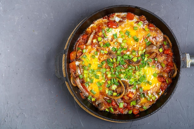 Shakshuka com ervas em uma frigideira em um espaço de cópia de fundo cinza