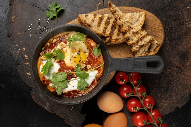 Shakshuka do estilo do chef. um prato clássico israelense de ovos fritos em molho de tomate, pimenta, cebola e temperos.