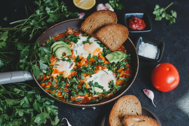 Shakshuka con huevos, tomate, pimiento y perejil