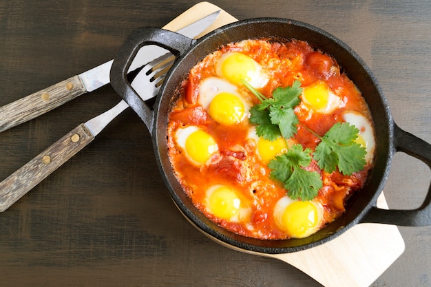 Shakshuka in der Pfanne. Omelett mit Tomaten, Pfeffer, Gemüse und Kräutern.