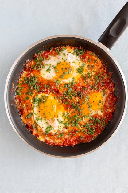 Shakshuka in einer Pfanne orientalisches traditionelles Gericht Spiegeleier mit Tomaten Pfeffer Gemüse und