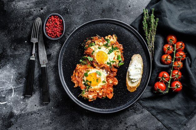 Shakshuka en un plato oscuro con ingredientes frescos