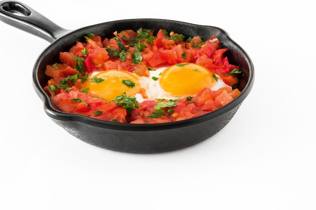 Shakshuka en sartén de hierro aislado en blanco. Comida típica en Israel.