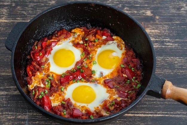 Shakshuka Spiegeleier mit Tomaten, Zwiebeln, Paprika und Gewürzen in Gusseisenpfanne