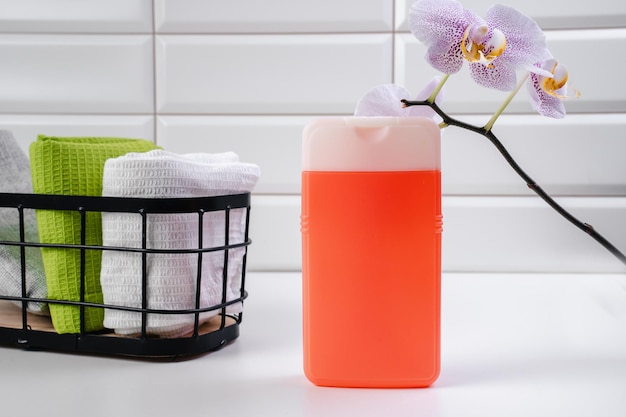 Shampoo auf weißem Fliesenhintergrund Duschgel mit Orchideen im Badezimmer Kosmetik für die Haut