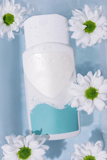 Shampoo ou produtos para cuidados com a pele e flores de camomila em uma superfície branca com água limpa