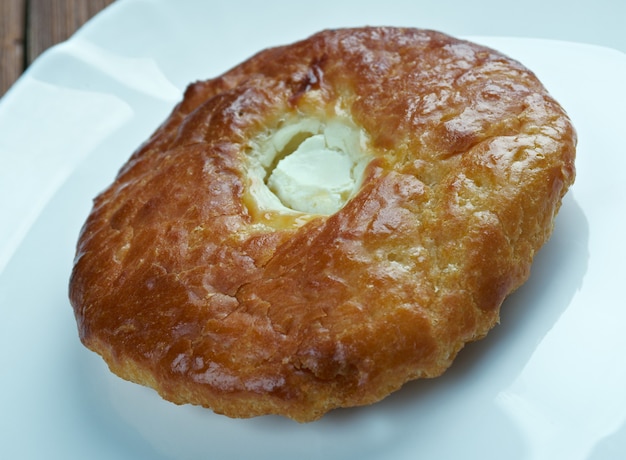 Shangii- empanadas con requesón pastelería rusa sobre un fondo de madera.