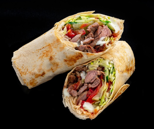 Shawarma de carne em um fundo escuro Shawarma com carne no pão pita