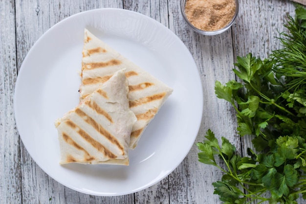 Shawarma em pão pita fino com frango e legumes em um prato