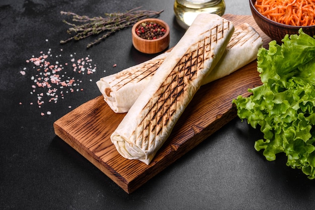 Shawarma fresco delicioso con carne y verduras en una mesa de hormigón oscuro. Comida rápida, cocina turca