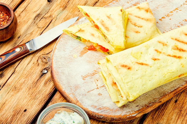 Shawarma oriental tradicional com frango, queijo e cogumelos a bordo da cozinha