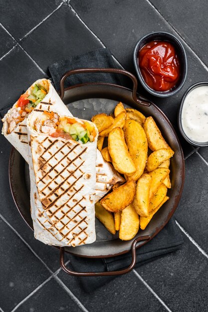 Shawarma Shaurma kebab com salada de legumes de carne e batatas fritas Fundo preto Vista superior