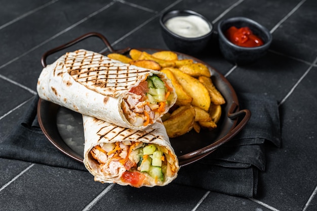 Shawarma Shaurma kebab con ensalada de verduras de carne y papas fritas Fondo negro Vista superior