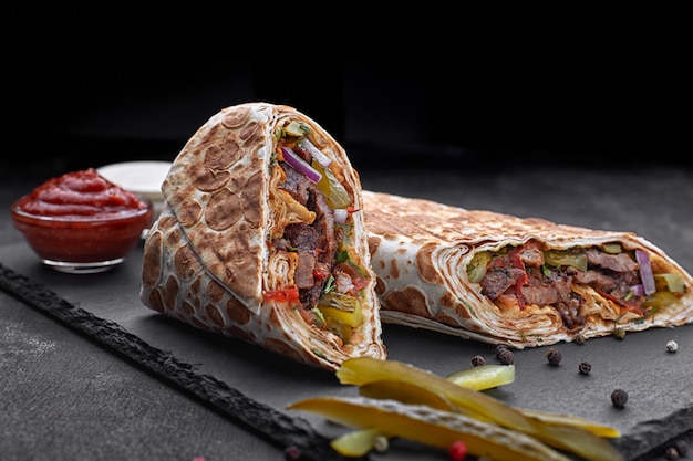 Shawarma con ternera, con salsa, cebolla, pepinillos, hierbas y pimiento rojo picante