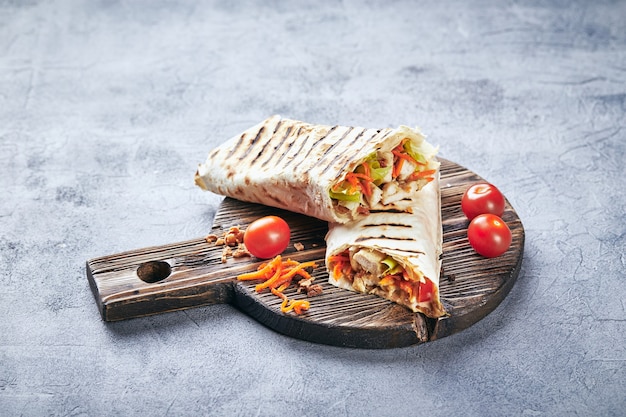 Shawarma tradicional oriental com frango e legumes, Doner Kebab com molhos na tábua de madeira. Comida rápida. Comida oriental.