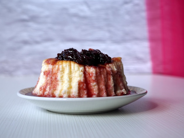 Sheesecake mit Sherry-Marmelade oder Sauce auf einem dekorierten weißen Teller