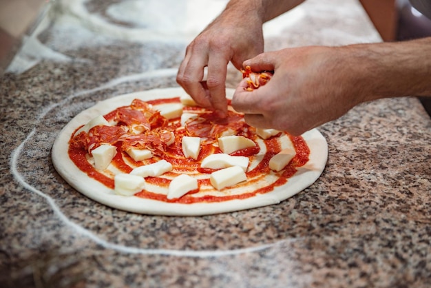 Shef cocinando pizza de cerca