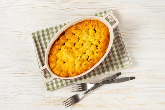 Shepherd's Pie o Cottage Pie plato tradicional británico sobre fondo blanco de madera