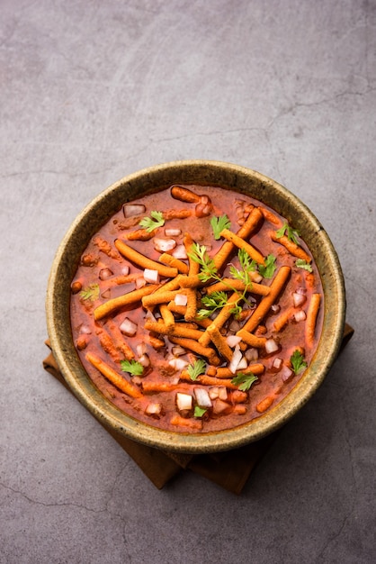 Shev Sabji o Kathiyavadi Dhaba. Curry de tomate picante, dulce y picante cubierto con crujiente Ganthia o gathia