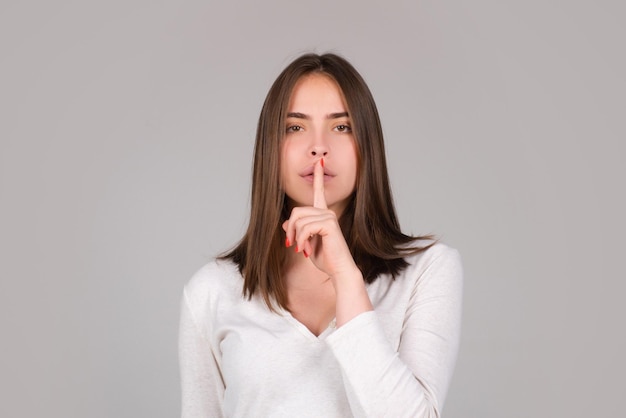 Shh womens secrets mujer mostrando signo secreto hembra con el dedo en la boca closeup retrato de joven w