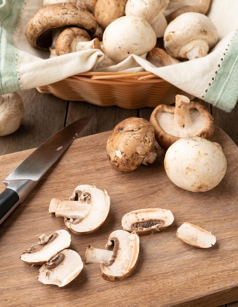 Shimeji Portobello und Pariser Pilze in einem Korb mit Scheiben über Holzbrett