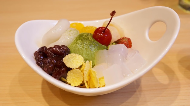 Shiratama Anmitsu sind klassische japanische süße Teigtaschen, serviert mit Matcha-Eiscreme, Ogura-Paste aus verschiedenen Früchten und garniert mit einer speziellen braunen Zuckersauce