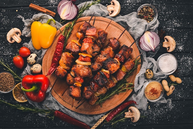 Shish kebab en brochetas con cebollas en la mesa de madera negra