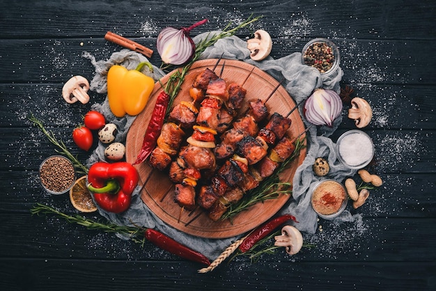 Shish kebab en brochetas con cebollas en la mesa de madera negra