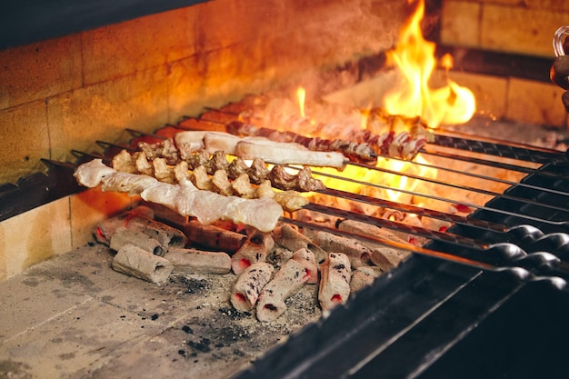 Shish kebab en brochetas de diferentes tipos de carne se fríe a la parrilla