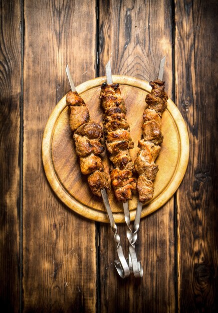 Shish kebab en brochetas. Sobre fondo de madera.