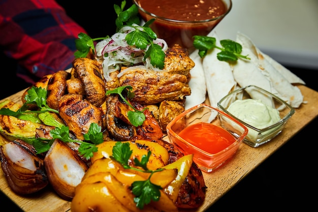 Shish kebab con lavash de verduras a la plancha y salsas