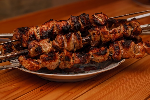 Foto shish kebab num prato sobre uma mesa de madeira. shashlik.