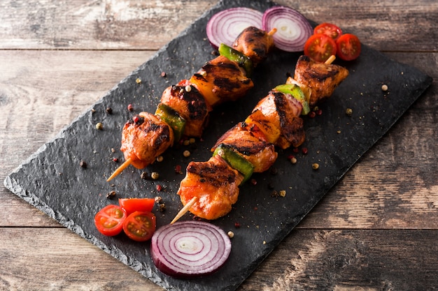 Shish kebab de pollo con verduras en la mesa de madera