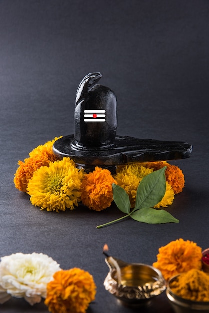 Foto shiva linga decorado con flores y bel patra u hoja y haldi kumkum para pooja o adoración del señor shiva o shankar bhagwan