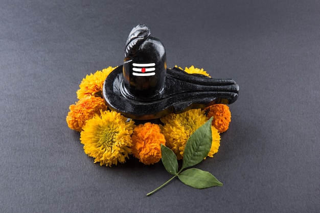 Shiva Linga decorado con flores y bel patra u hoja y haldi kumkum para Pooja o adoración del Señor shiva o Shankar bhagwan